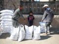 Gazatíes junto a sacos de comida de la UNRWA