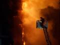 Un bombero trata de apagar el edificio en llamas en el barrio valenciano de Campanar