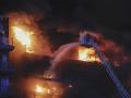 Un bombero subido a una escala lucha contra las llamas en el edificio devorado por las llamas en Valencia