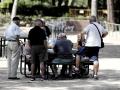 Varios pensionistas juegan al dominó en un parque de Madrid.