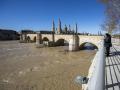 Dos personas observan la crecida del río Ebro a su paso por Zaragoza