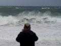 Un hombre observa las olas durante el frente meteorológico, a 23 de febrero de 2024, en La Coruña