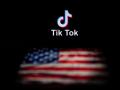 El logotipo de la aplicación de red social TikTok y una bandera de Estados Unidos
