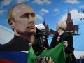 Mujeres posan frente a un mural que representa al presidente ruso Vladimir Putin después de votar en las elecciones presidenciales de Rusia
