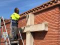 Un operario retira la cruz de Bechí, en Castellón, para devolverla a su emplazamiento anterior