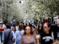 Varias personas pasean junto a árboles en flor durante el primer día de primavera en Madrid