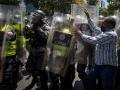 Manifestantes se enfrentan a policías durante una protesta en la que piden mejoras salariales, en Caracas (Venezuela)