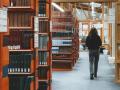 Una persona pasea por la biblioteca de una universidad