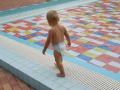 Un niño pequeño se alivia del calor en una piscina