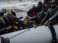Inmigrantes en un bote en el mar frenete a la isla griega de Lesbos