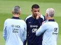 Kylian Mbappe charla con el cuerpo técnico de Francia en un entrenamiento