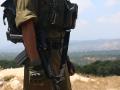 Un soldado israelí en una posición de vigilancia frente a la frontera con el Líbano (al fondo)