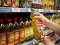 Una persona sostiene una botella de aceite en un supermercado de Barcelona.