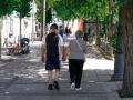 Una pareja de ancianos camina por la calle cogida de la mano.