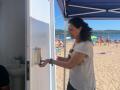Una persona usa un dispensador de crema solar