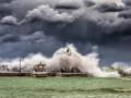 Una ola golpea un faro