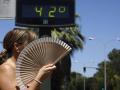 Una mujer se abanica mientras pasa por un termómetro de calle que marca 42 grados n Córdoba
