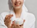 Mujer aplicándose crema en el rostro