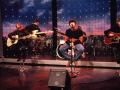Oasis durante una actuación en 1994 (Liam en el centro y Noel a la derecha)