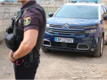 Imagen de un agente y un coche patrulla de la Policía Nacional.