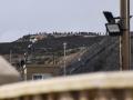 ecenas de personas se congregan en un monte cercano a la frontera con Ceuta para intentar cruzar a la ciudad española