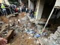 La gente comprueba los daños en el lugar de un ataque israelí en los suburbios del sur de Beirut