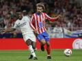 El delantero del Atlético de Madrid Antoine Griezmann pelea una posesión con el delantero brasileño del Real Madrid Vinicius