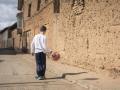 Un niño juega en una calle desierta de un pueblo