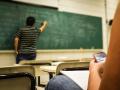 Un profesor escribe en la pizarra de un aula