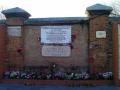 Tapia del cementerio de la Almudena con la placa de Las 13 Rosas