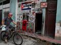Un hombre en bicicleta pasa frente a una casa con imágenes de Fidel y del Che en La Habana