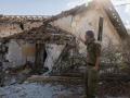 Un soldado israelí señala una casa alcanzada por cohetes de Hezbolá en la desierta ciudad de Metula, en el norte de Israel, cerca de la frontera con Líbano