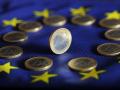 Euro coins lie on a Euro flag.
