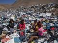 Varias mujeres buscan ropa usada entre toneladas de desechos en el desierto de Atacama