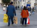 Dos personas llevan varias bolsas de compra durante Black Friday.