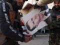 Islamistas queman una foto del presidente de Siria, Bashar al-Asad tras entrar en Alepo