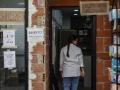 Una mujer, en la entrada de una farmacia afectada por la DANA, en Paiporta
