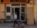 Una mujer pasa frente a la puerta de un bar de Paiporta, Valencia