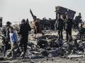 La gente recoge metal y municiones sin explotar en el lugar del ataque aéreo israelí de la noche anterior que tuvo como objetivo cargamentos de armas que pertenecían a las fuerzas del gobierno sirio en Qamishli, en el noreste de Siria