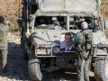 Un soldado israelí sostiene un retrato del presidente Bashar Al Assad cerca de la aldea drusa de Majdal Shams en los Altos del Golán