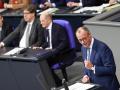 Friedrich Merz, líder de la Unión Demócrata Cristiana de Alemania, y al fondo el canciller Olaf Scholz