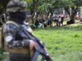 Soldados del ejército colombiano hacen guardia junto a personas desplazadas por los recientes enfrentamientos entre grupos armados que llegaron al municipio de Tibú,