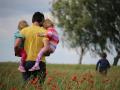 Un padre con sus hijas en brazos