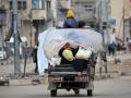 Palestinos transportan sus pertenencias en el campo de refugiados de Bureij, en el centro de Gaza