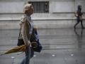 Una mujer con gabardina y paraguas en Sevilla