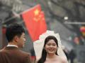 Una pareja posa para sus fotos de boda en una calle cerca de la Ciudad Prohibida en Pekín