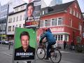 Un hombre en bicicleta pasa junto a un cartel del líder de Los Verdes y la líder de Sarah Wagenknecht