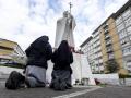Dos religiosas rezan por Francisco ante la estatua de Juan Pablo II en el hospital Gemelli