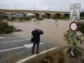 Una persona toma una imagen del caudal del río Palancia a su paso por Sagunto cuando varias carreteras de las provincias de Valencia y Castellón permanecen cortadas debido a la lluvia