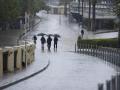 Varias se protegen de la lluvia con un paraguas en Sevilla